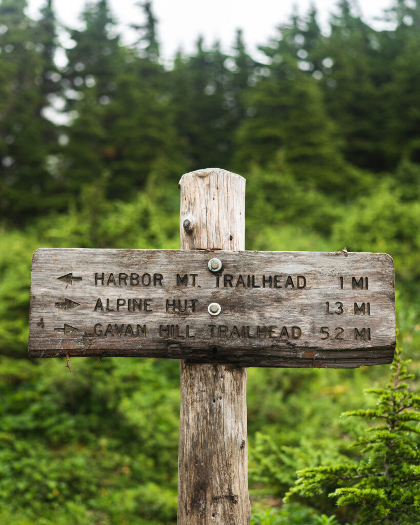 Trail sign showing the way to Harbor Mt. Trailhead, Alpine Hut, and Gavan Hill Trailhead.